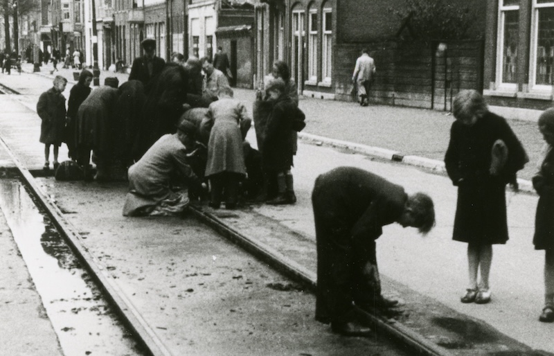Kinderen verzamelen takken in wat over is van de Scheveningse Bosjes. Fotograaf L.H. Zieck, 1944