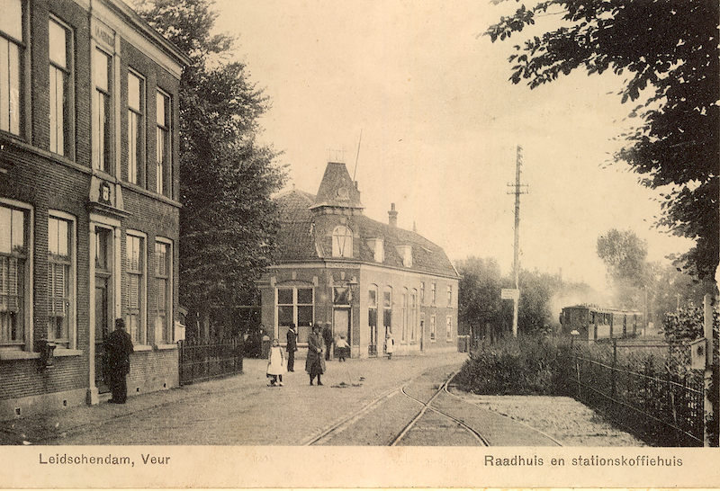 Zicht op de Veursestraatweg met geheel links het voormalige gemeentehuis van Veur en het stations koffiehuis ‘het wapen van Veur’ en rechts de stoomtram in 1915