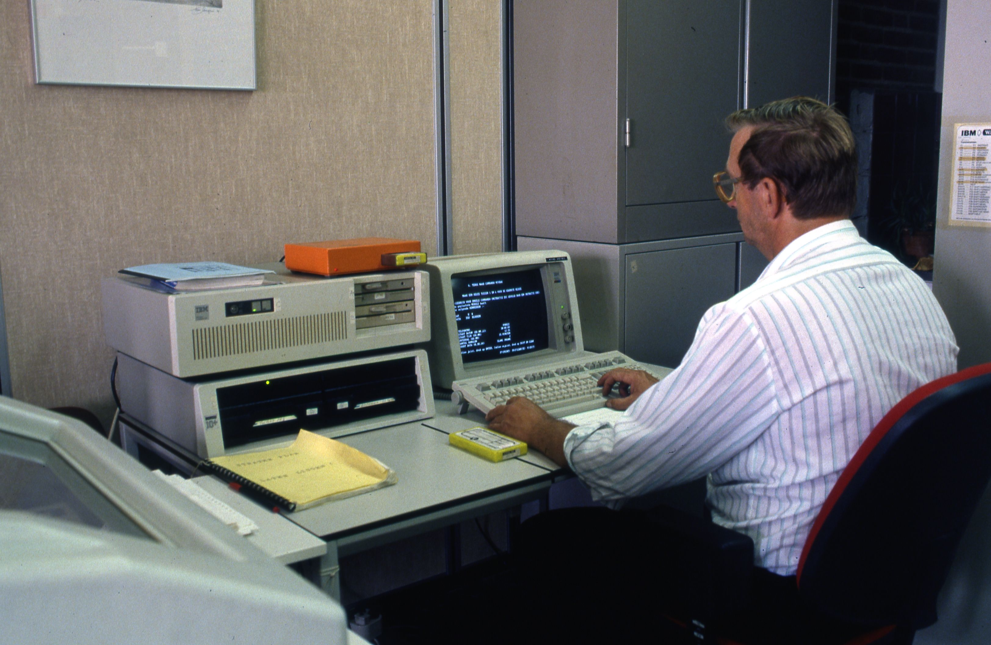 Man aan het werk met IBM apparatuur Gemeentelijk Centrum voor Automatisering. Maker: Dienst voor stadsontwikkeling 1985